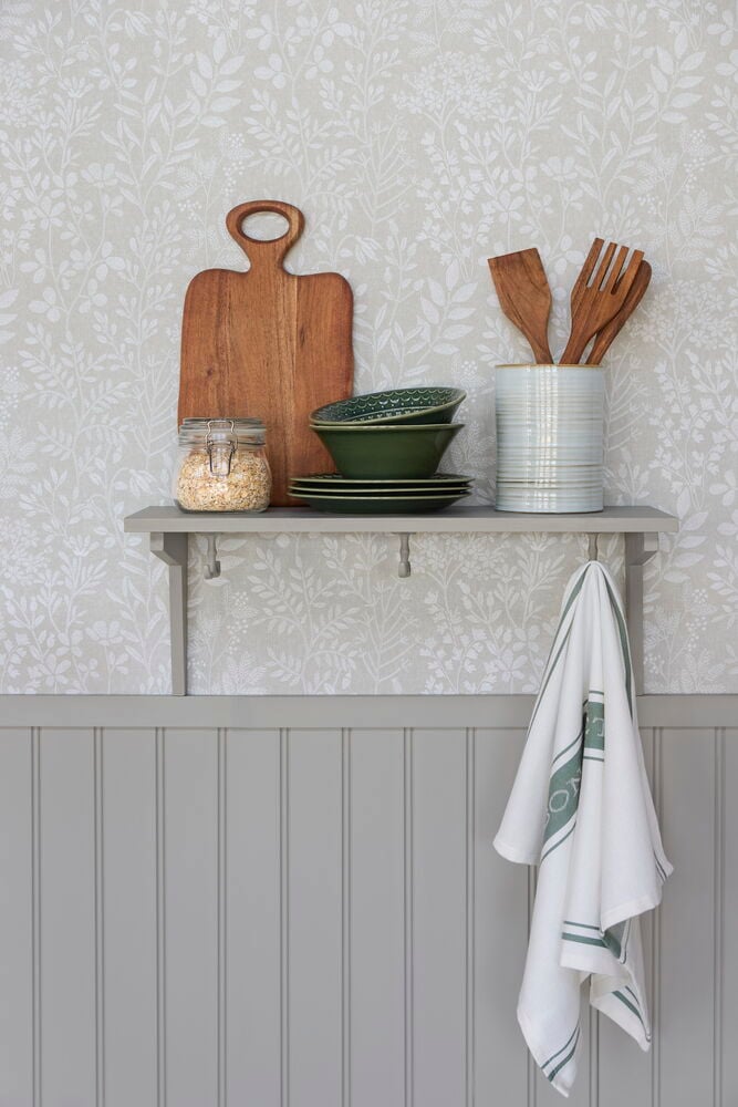 Beige Tapete mit weißen organischen Mustern, mit einem grauen Regal mit Küchenutensilien und einem Handtuch.