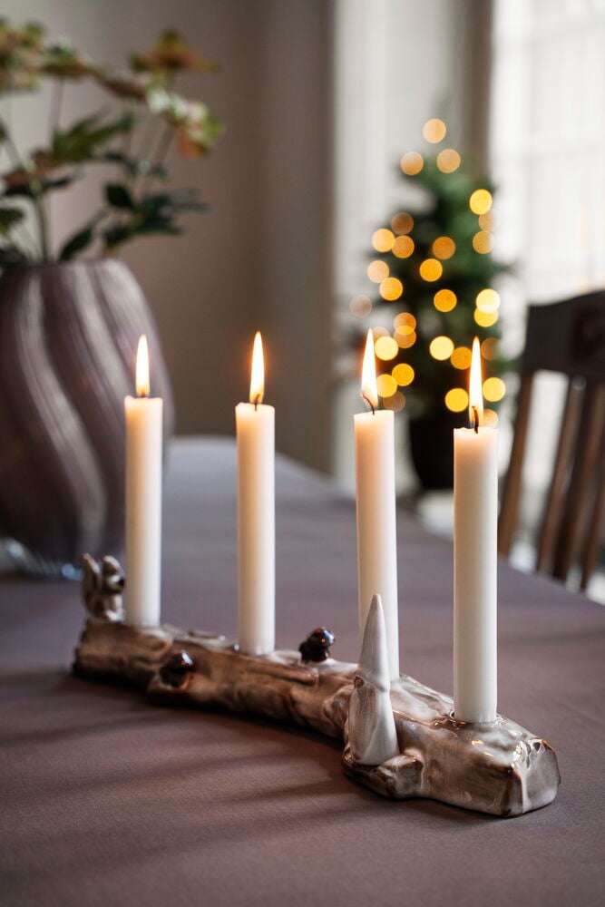 Kerzenständer Fauna, ein keramik-blockförmiger Halter mit vier angezündeten weißen Kerzen und kleinen Figuren.