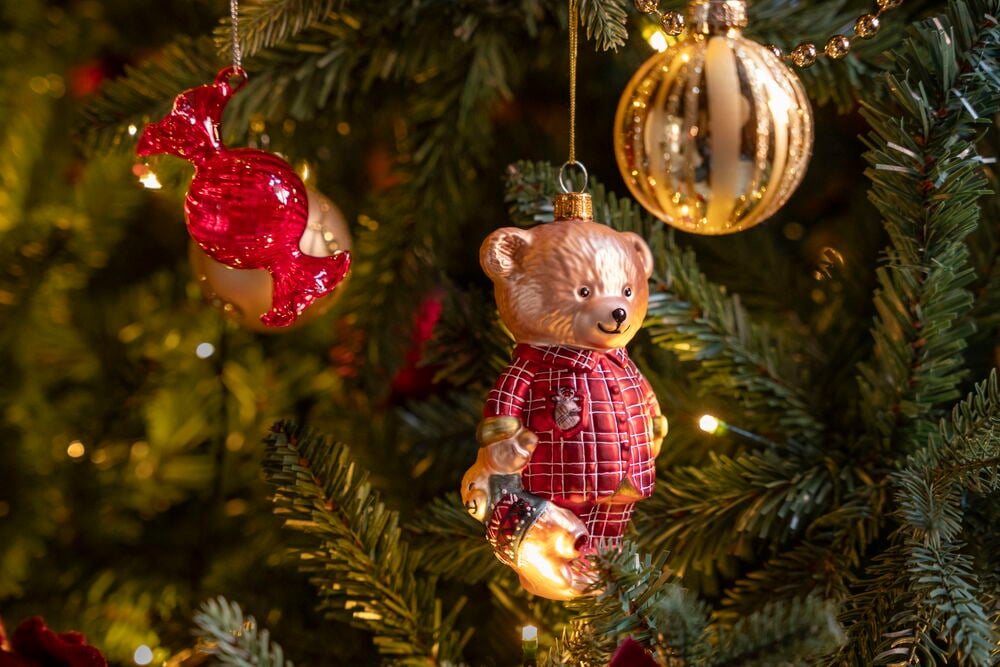 Rød glass godteri juletrepynt, en rutete skjorte teddybjørn ornament, og en gullfarget riflet kule.
