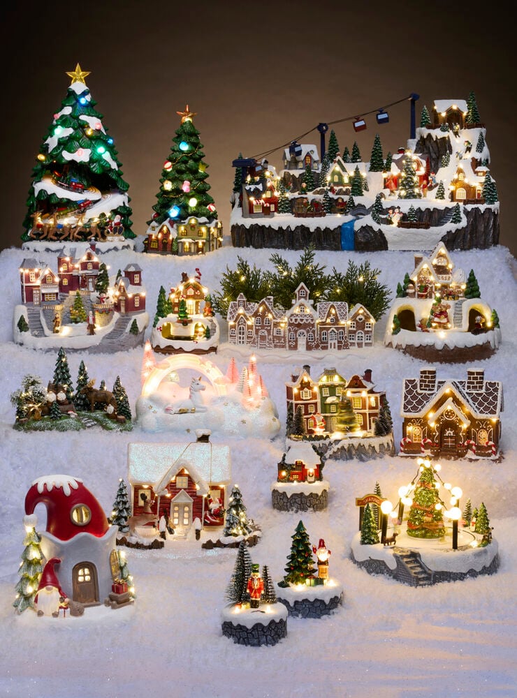 Weihnachtsdorf Lillehammer, eine Sammlung beleuchteter Häuser, Bäume und Figuren auf Schnee.