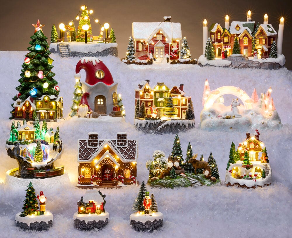 Verschiedene beleuchtete batteriebetriebene Weihnachtsdörfer und festliche Dekorationen im Schnee.