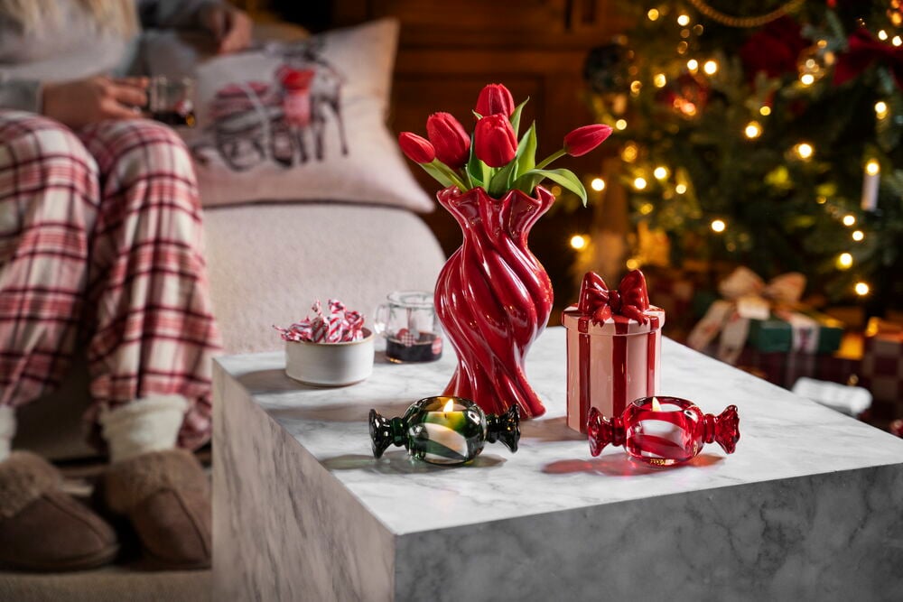 Rote, gedrehte Vase Agnes 21 cm mit Tulpen, grünen und roten Bonbon-Kerzenhaltern und einer gestreiften Geschenkbox.