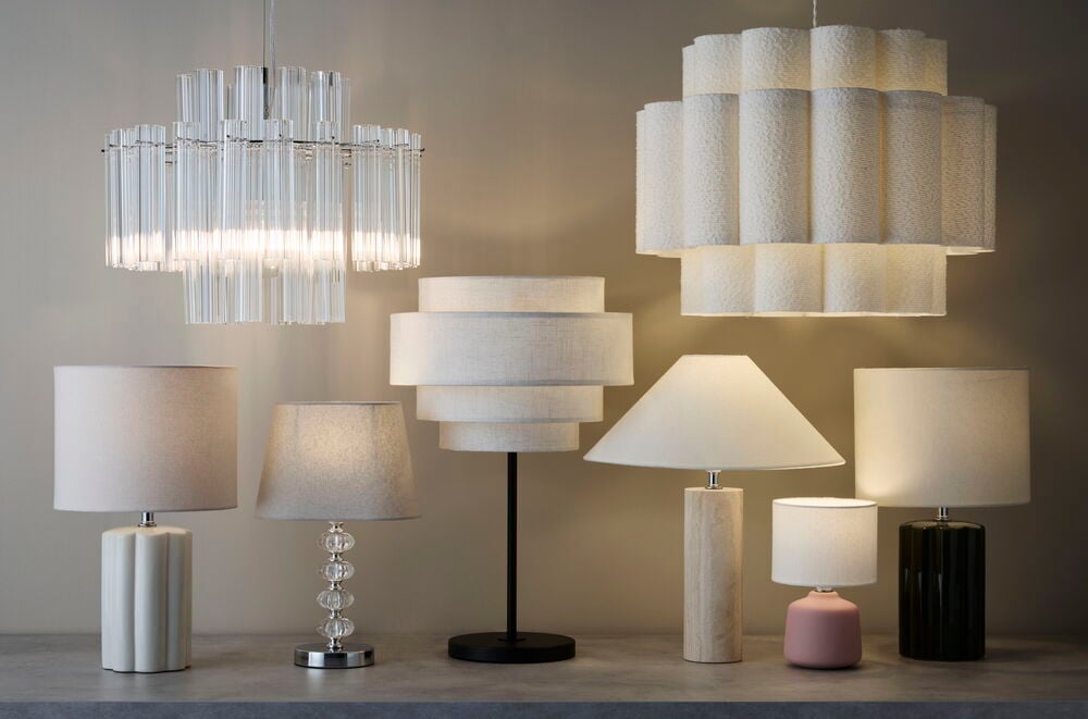 Lampskärm Cannes 16x23 cm Grå på klar kristallbas, tillsammans med olika taklampor och bordslampor.