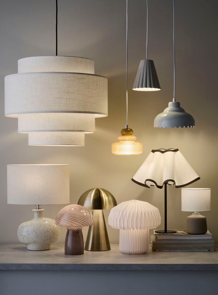 Bordslampa Porano, en rosa-brun virvlande glas svamplampa, med olika pendel- och bordslampor.