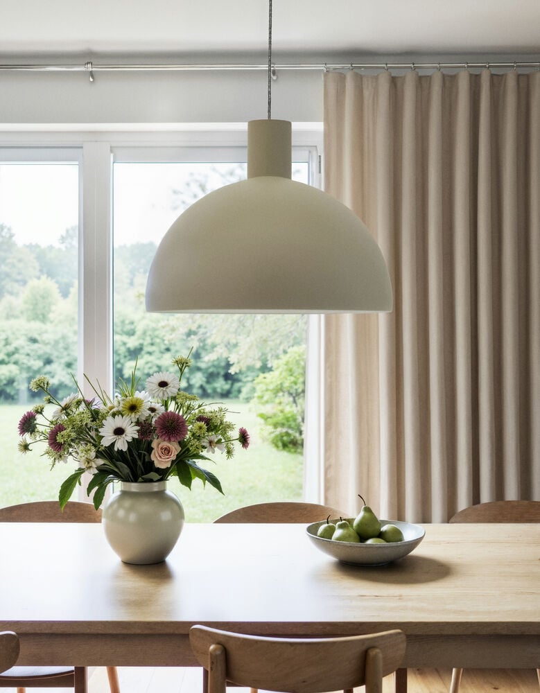 Beige taklampa över matbord med blommor och frukt.