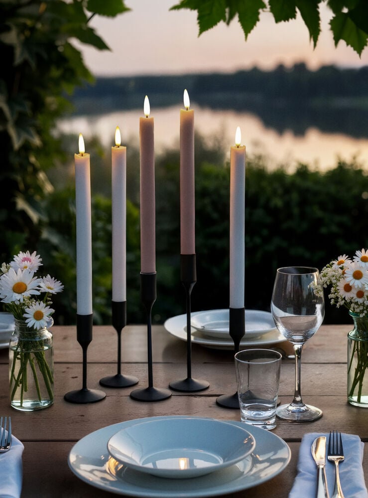 Kuusi LED-kynttilää eri väreissä katetulla pöydällä.