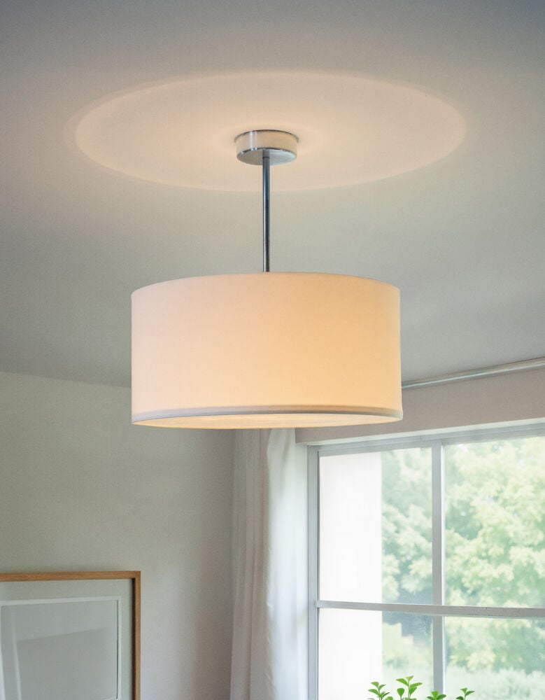 Taklampa med rund textilskärm och metallarm.