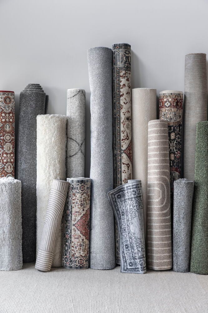 Flera upprullade mattor i olika färger och mönster.