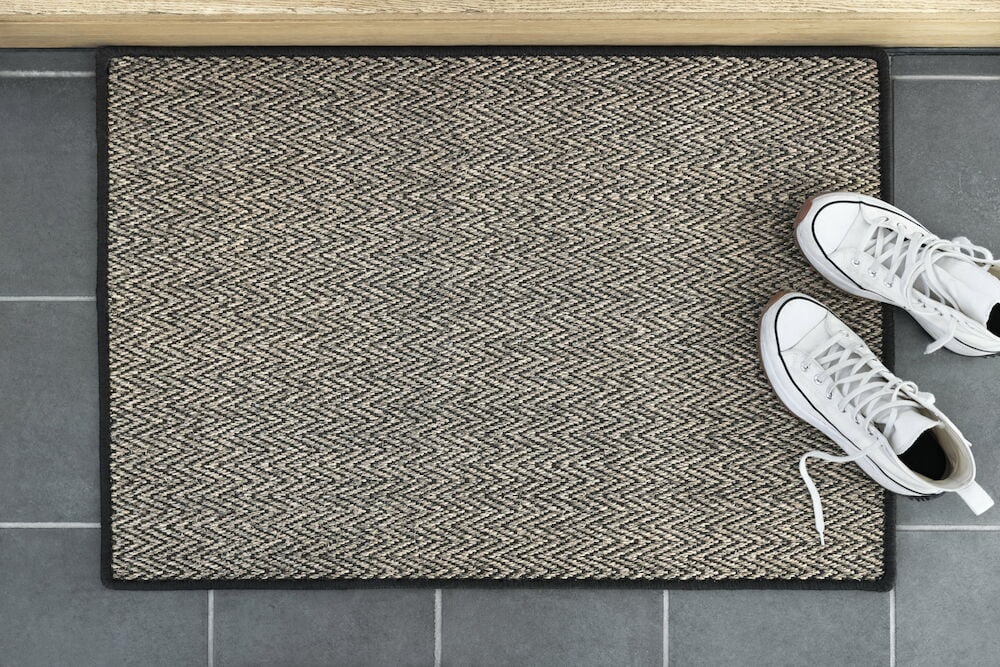 Ruskea ovimatto siksak-kuviolla ja valkoiset kengät.