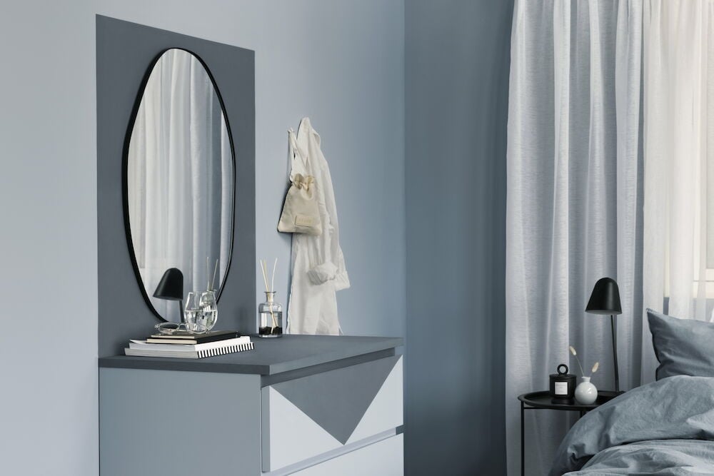 Sovrum med blå väggfärg och moderna möbler.