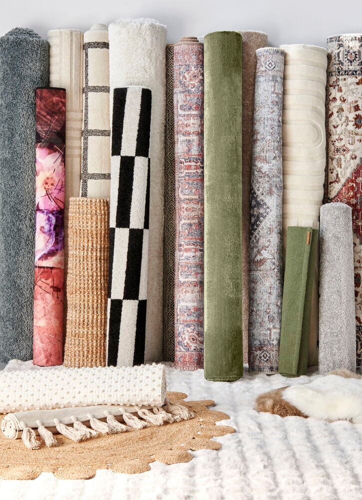 Flera upprullade mattor i olika färger och mönster.