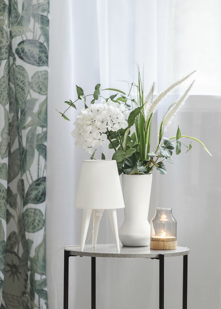 Kaksi valkoista polyesteriverhoa roikkuu ikkunassa.