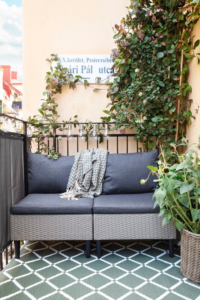 Balkonsichtschutz 250x80 cm Grau 100 % Polyester, mit einem Outdoor-Sofa, Chevron-Decke und grünem Teppich.
