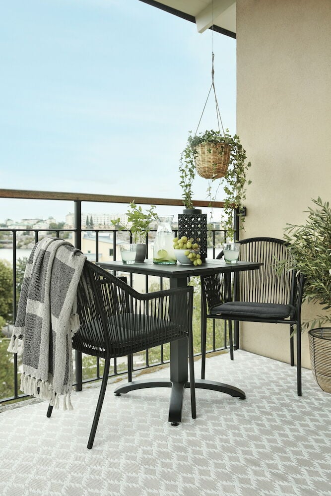 Grå bastmatta med dekorativt mönster på balkong.