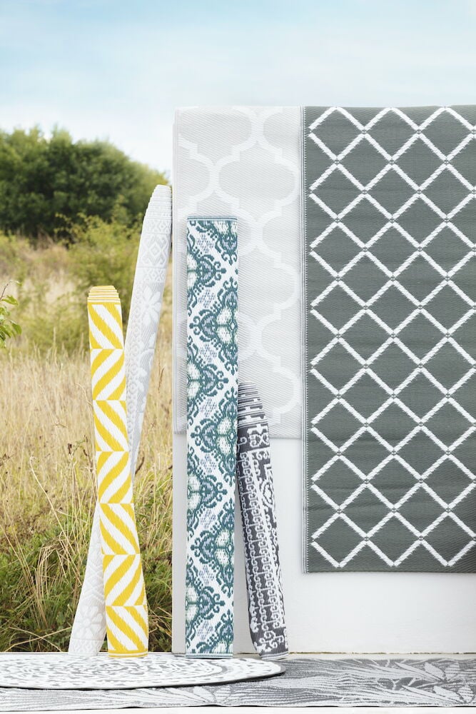 Rund bastmatta antracit med rutigt vitt mönster.