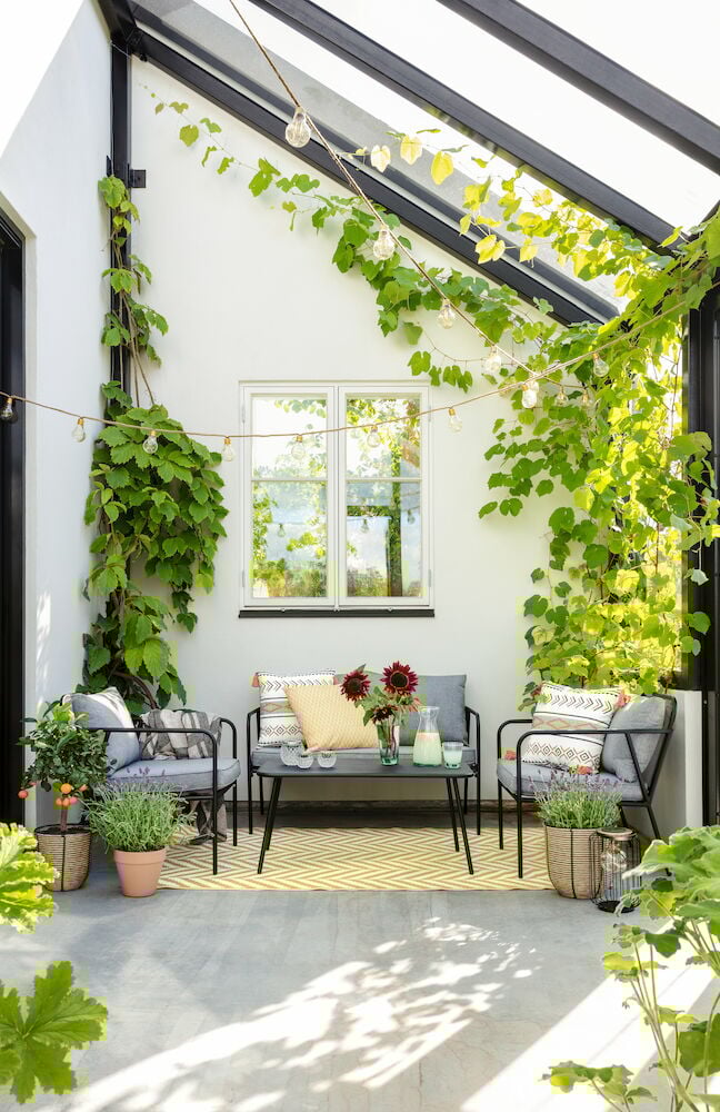 Musta metallipöytä, jossa on verkkokuvioinen pöytälevy ulkokäyttöön.