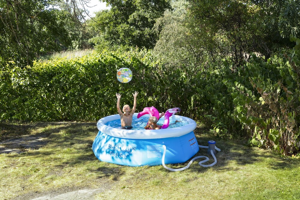 Blått Basseng Fast Set 1880 liter med to barn, en fargerik badeball og en rosa flamingo-badering.