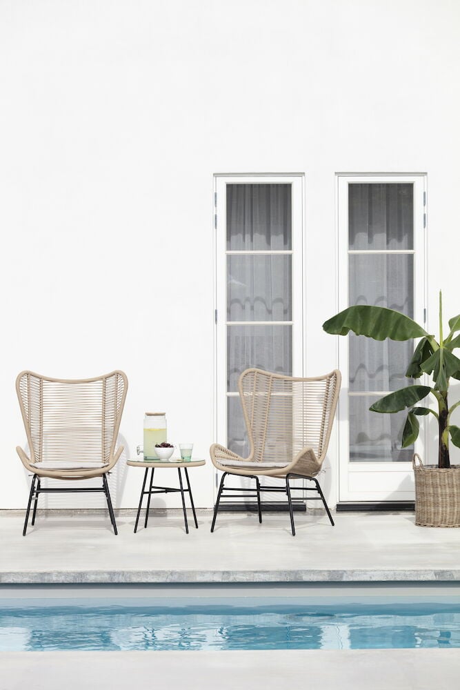 Pieni sivupöytä luonnonvärisenä kahden tuolin vieressä.