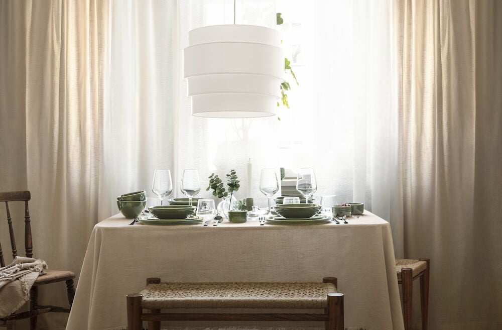 Beige duk med fransar på dukat matbord.