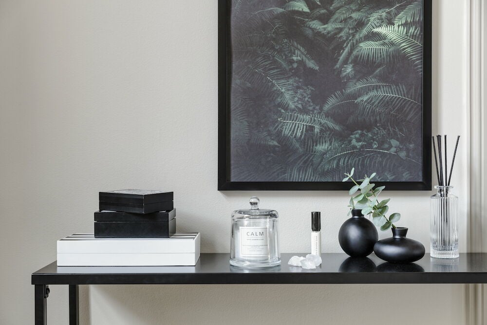 Durchsichtige gerippte Glasflasche mit Duftstäbchen auf dem Tisch.