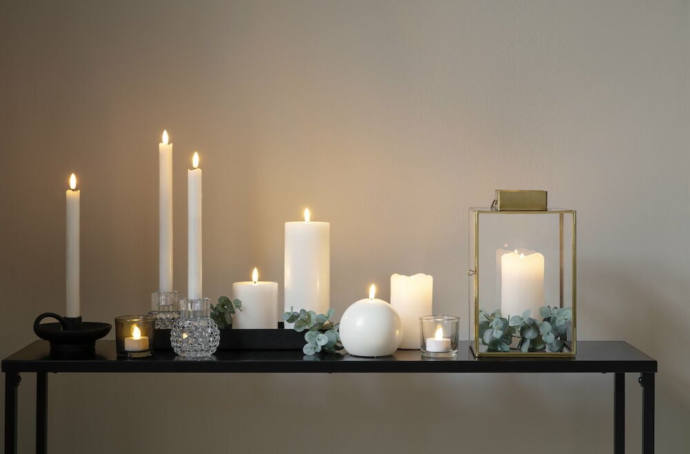 Svart avlastningsbord med tända ljus och dekorationer.