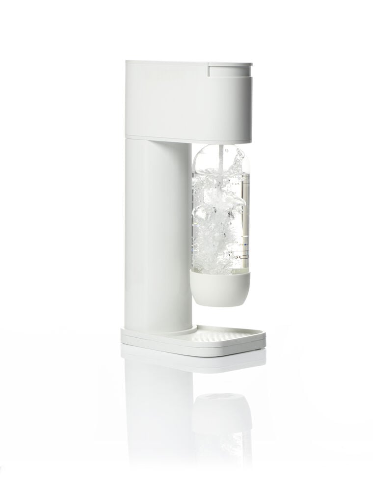 Vit kolsyremaskin med genomskinlig flaska och bubblor.