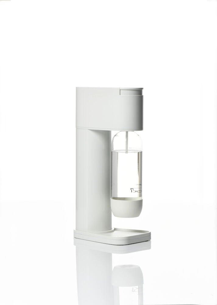 Vit kolsyremaskin med transparent flaska på blank yta.