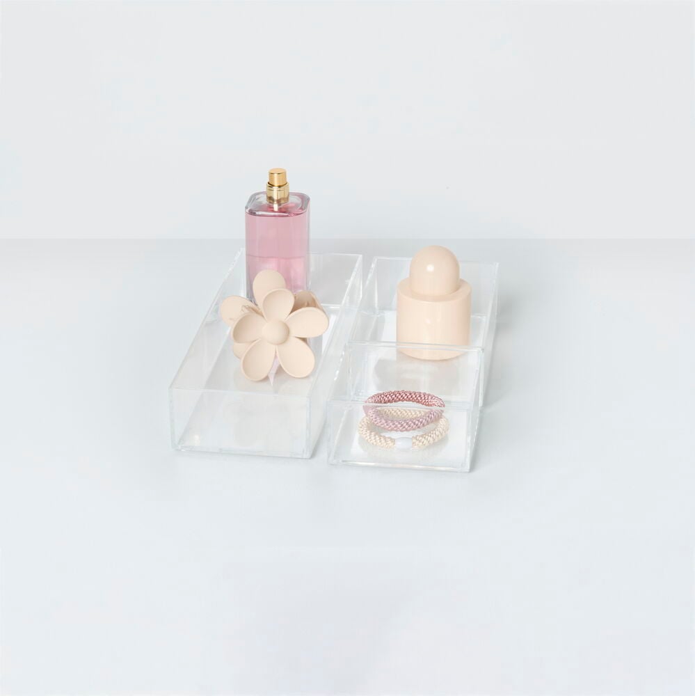 Tre transparenta plastlådor med småsaker och accessoarer.