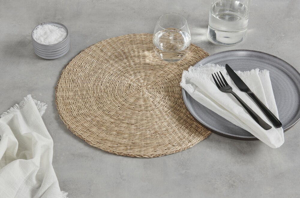 Pyöreä pöytätabletti meriruohosta katetulla pöydällä.