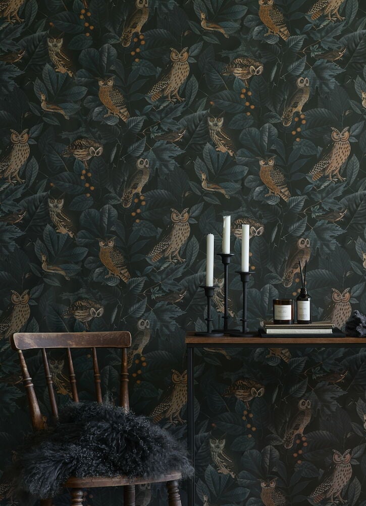 Mörkgrön tapet med ugglemönster och naturmotiv.