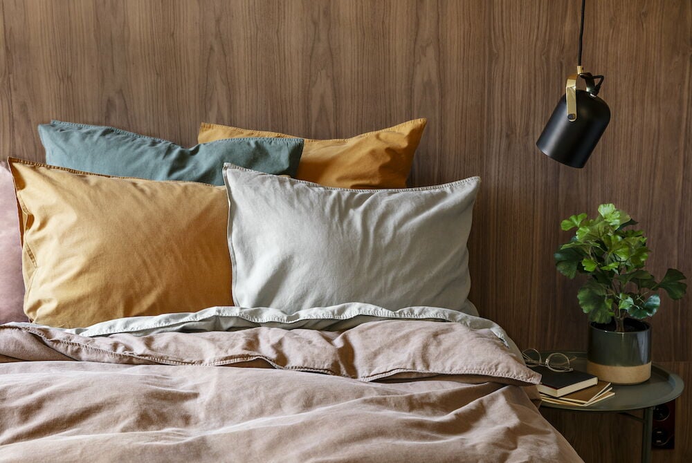 Brunt påslakanset i bomull på bäddad säng.