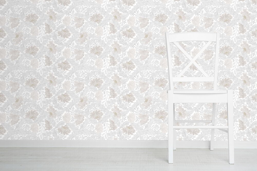 Vit stol mot grårosa blomtapet med dahliamönster.