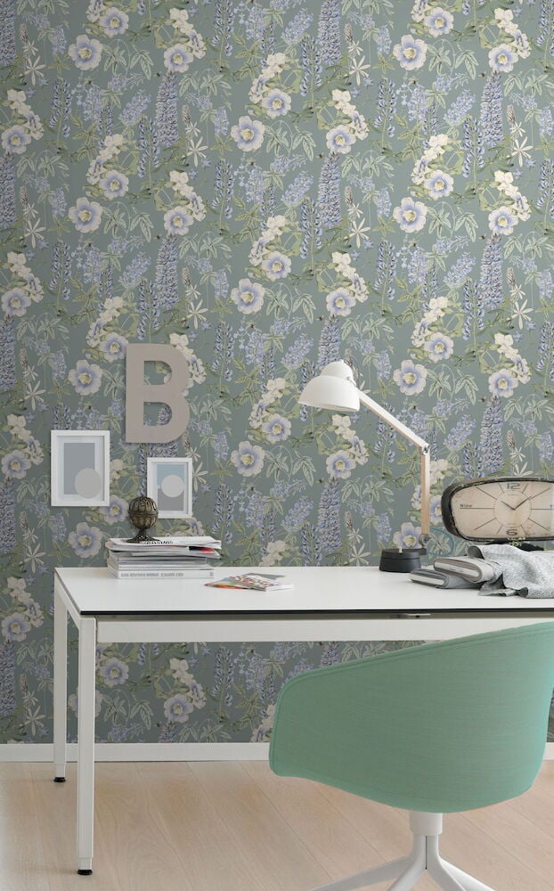 Skrivebord med grå blomstrete tapet i bakgrunnen.