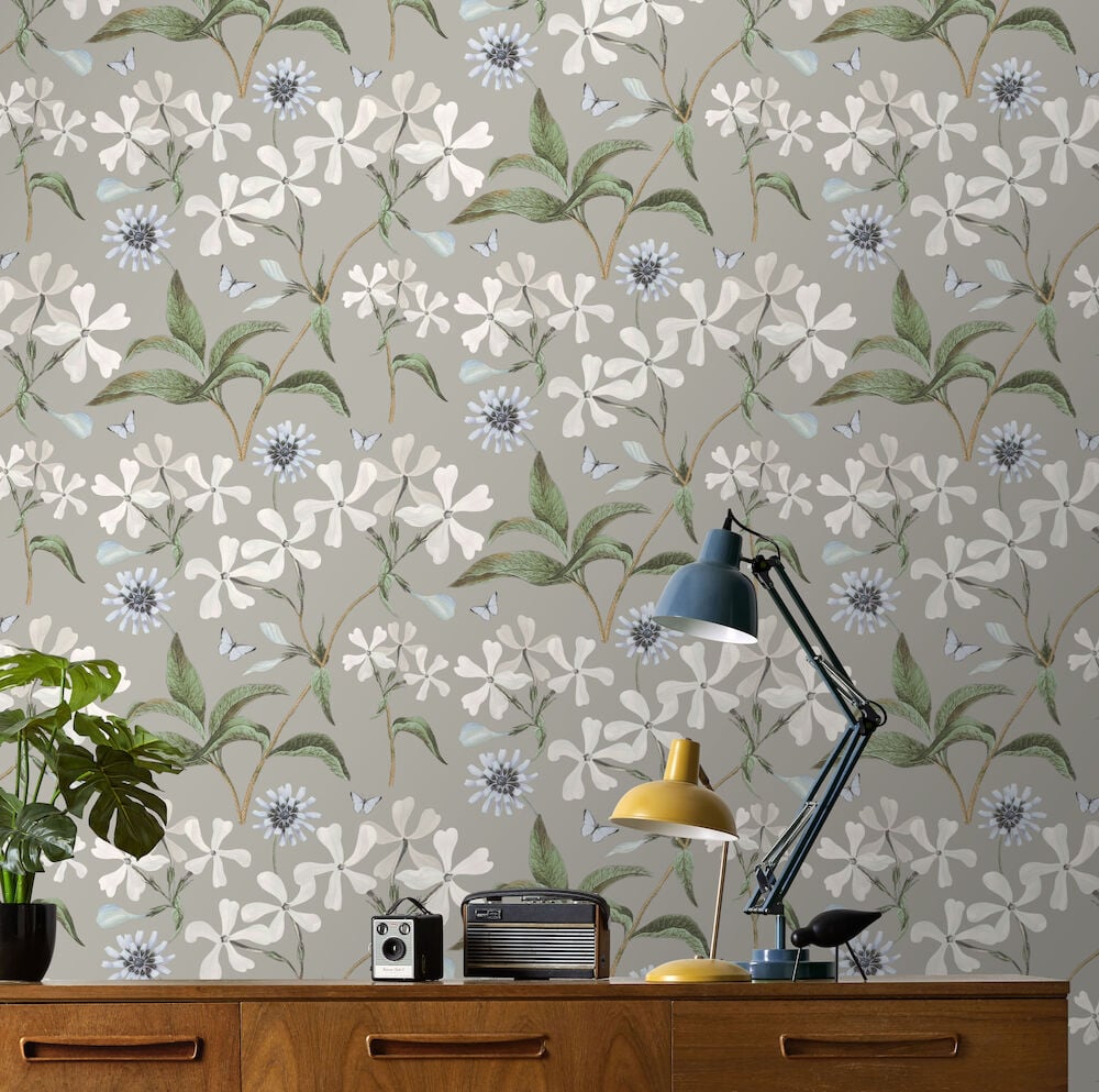 Blommig grå tapet bakom skrivbord med lampor.