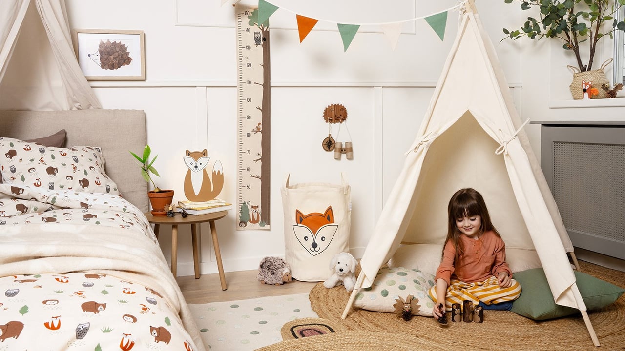 Barnrum i naturnära färger. Säng med sänghimmel och barn som leker i tipitält.