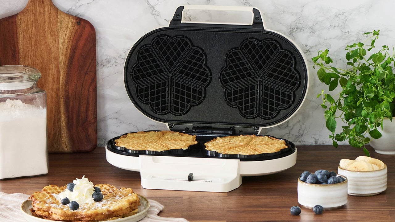 På kjøkkenbenken står det et dobbelt vaffeljern med to nystekte vafler.