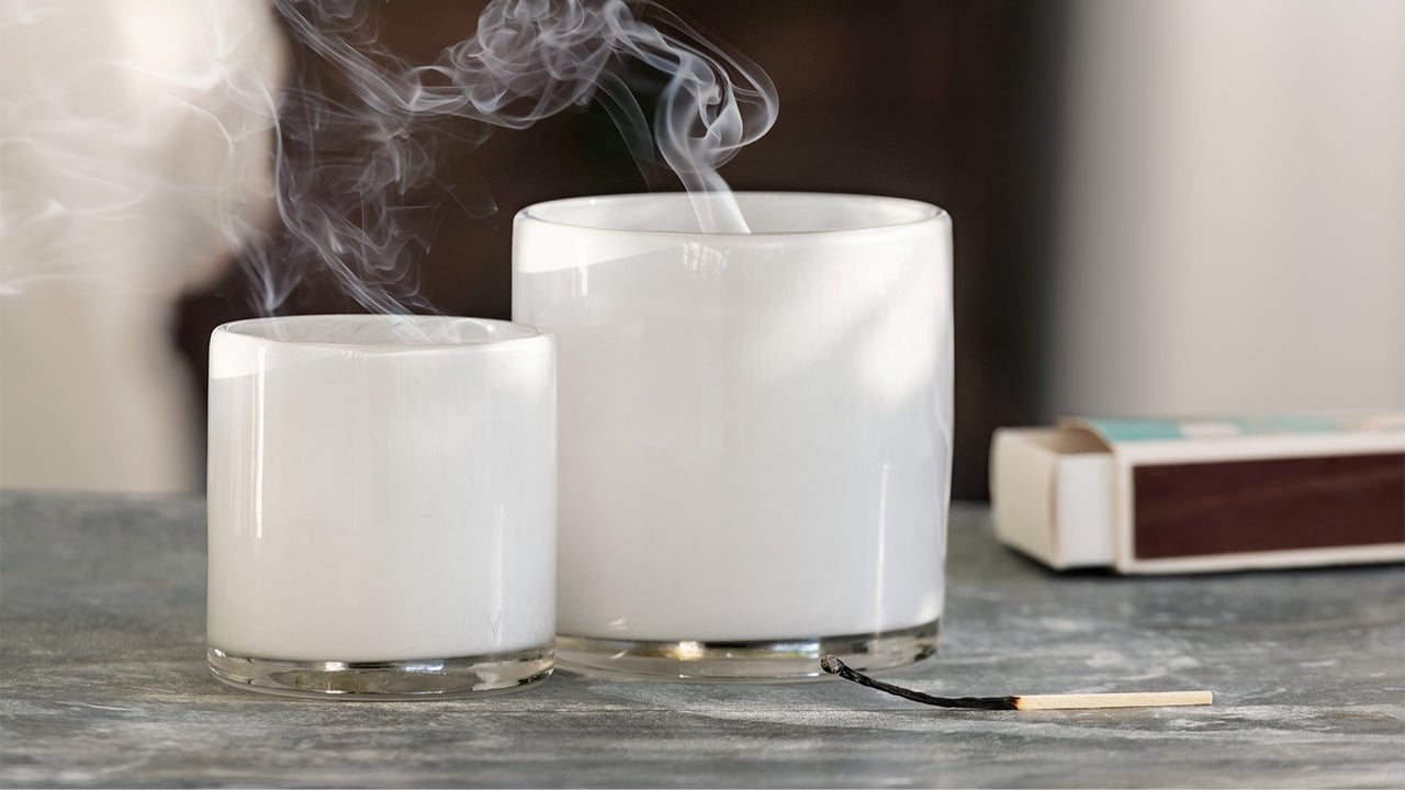 Två vita värmeljushållare i glas ryker efter att någon har släckt ljusen.