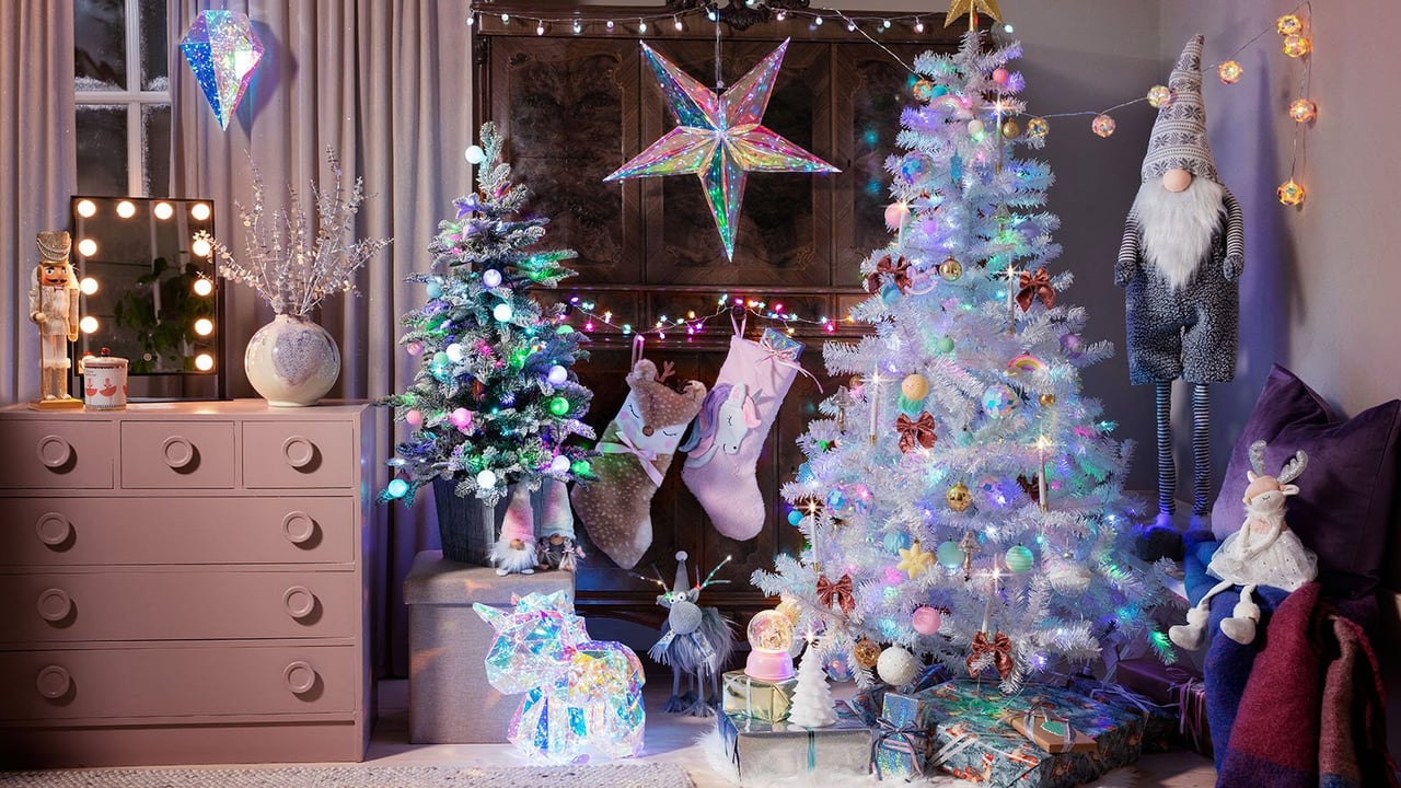 Huone, jossa on joulukuusi, joulutähti ja iloisia ja kimaltavia joulukoristeita.