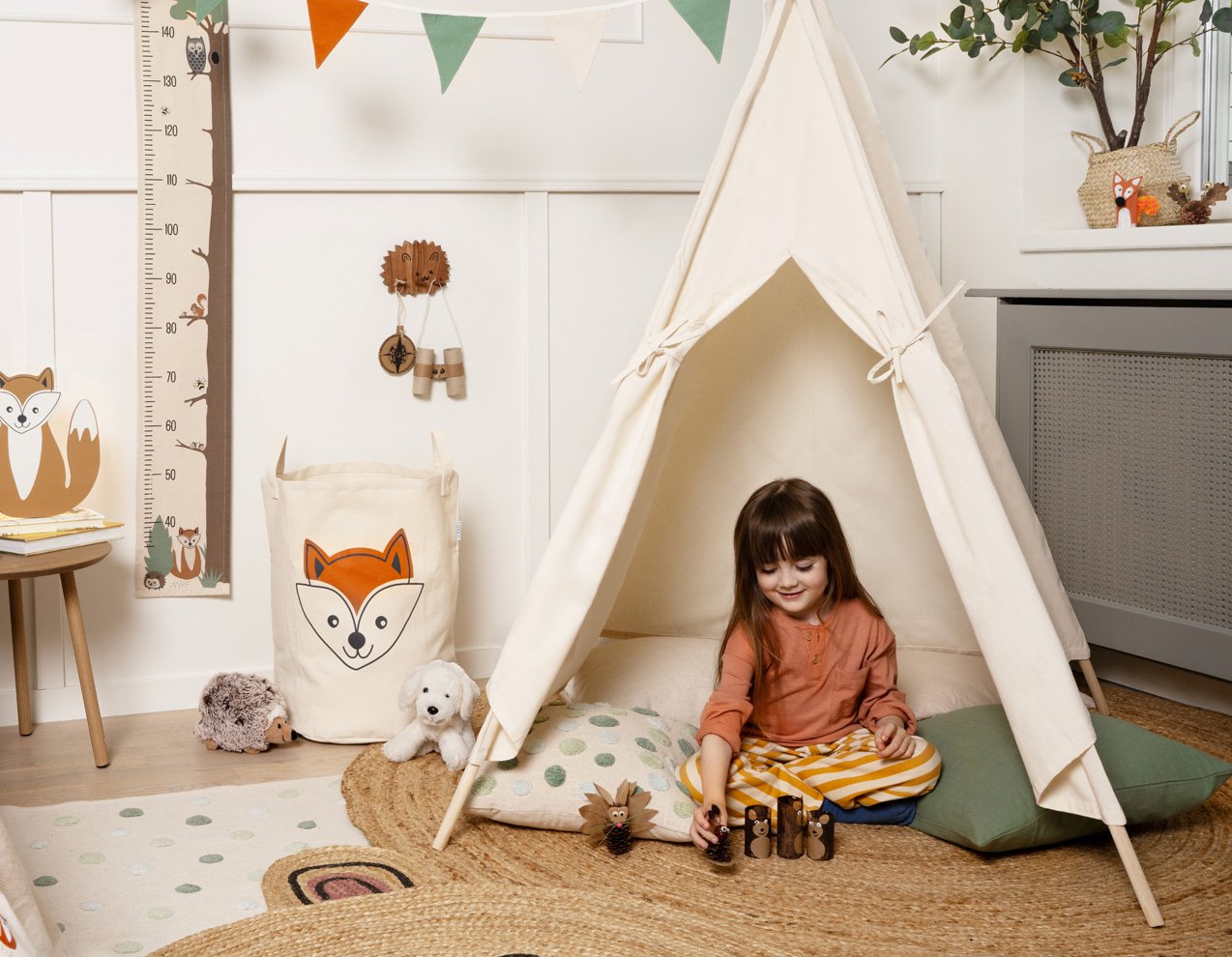 Barn leker i ett lektält i ett lekfullt inrett rum med djurtema.